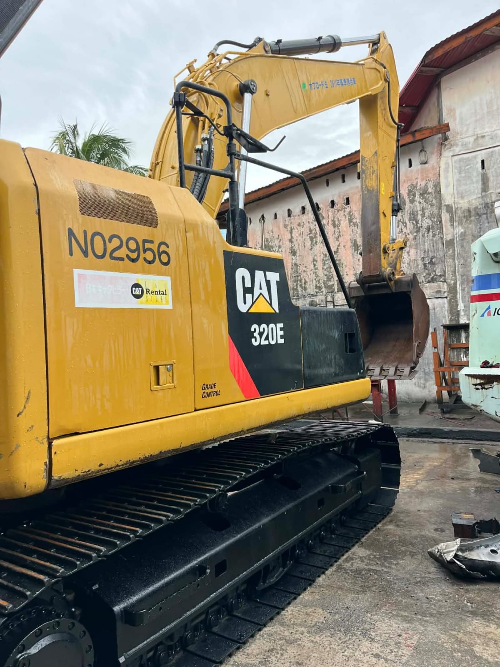 Caterpillar 320E tracked excavator with grade control, parked at the yard.